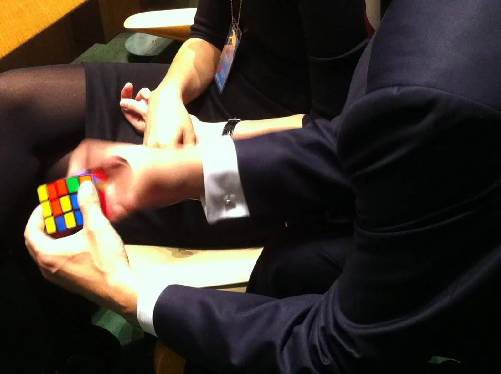 Two colleagues in business dress working together on a puzzle cube
